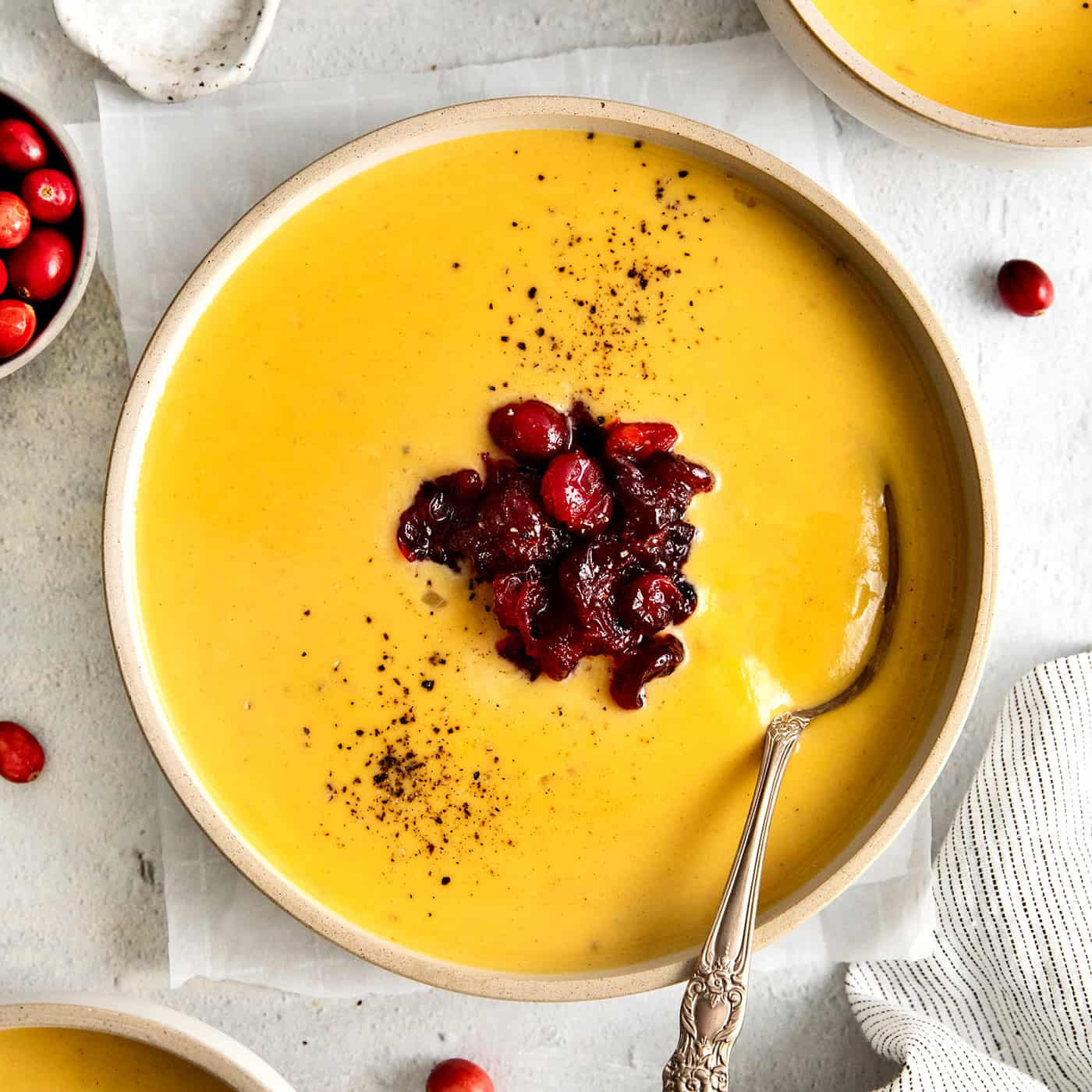 Overhead view of a bowl of squash soup with cranberry relish