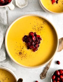 Overhead view of a bowl of squash soup with cranberry relish