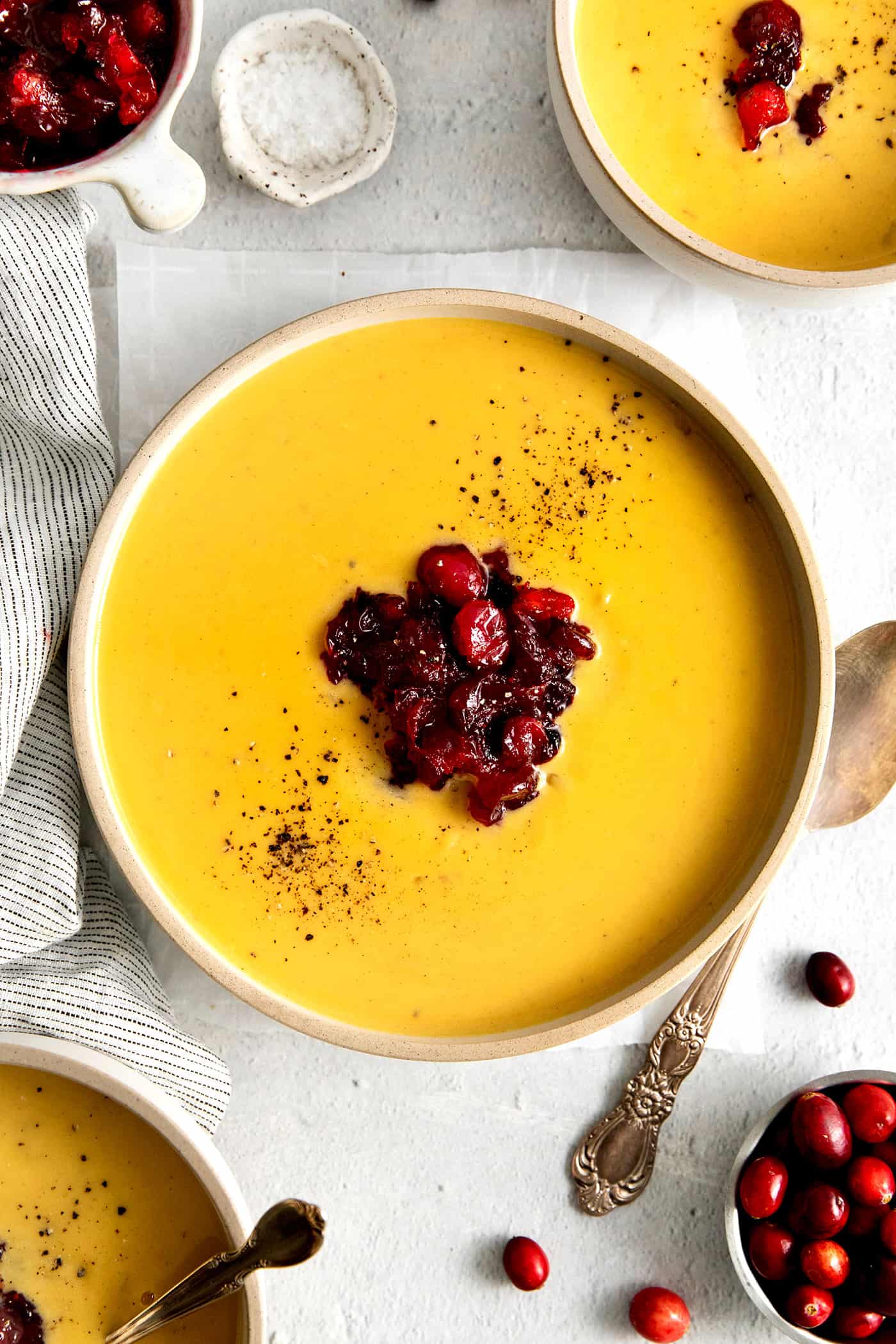 Overhead view of a bowl of squash soup with cranberry relish