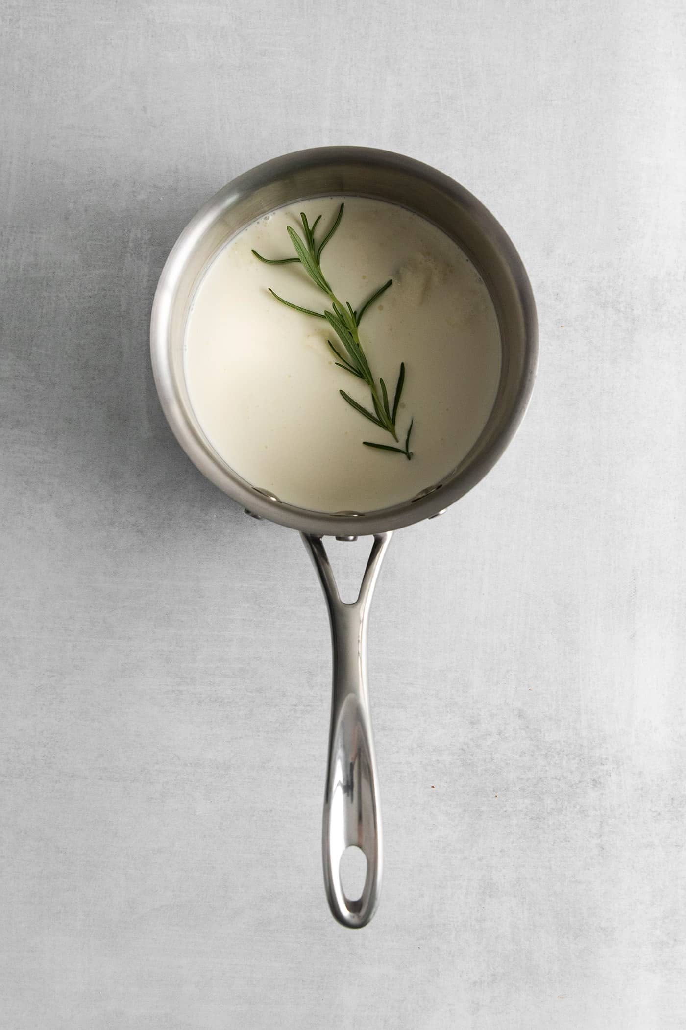 A rosemary spring in a saucepan of heavy cream