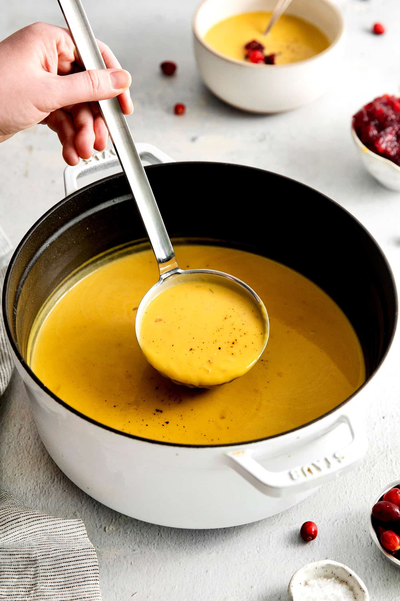 Squash soup being served in a metal ladle