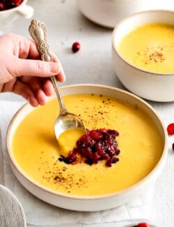 A spoon in a bowl of squash soup