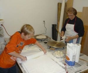 a kid and his grandma making lefse
