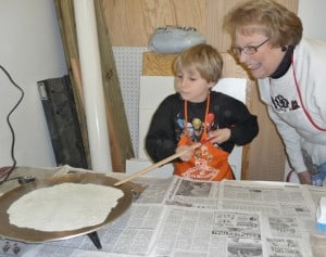 a kid and his grandma making lefse