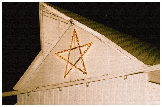 light-up star on a white barn