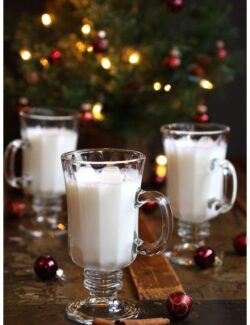 three glasses of almond steamer in front of a christmas tree