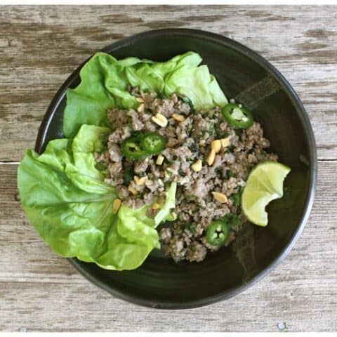 a pottery bowl of lettuce and ground pork