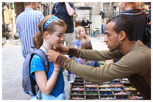 a man putting a necklace on a girl