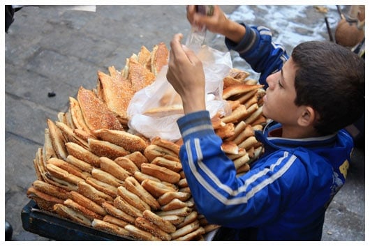 a young boy selling pastries