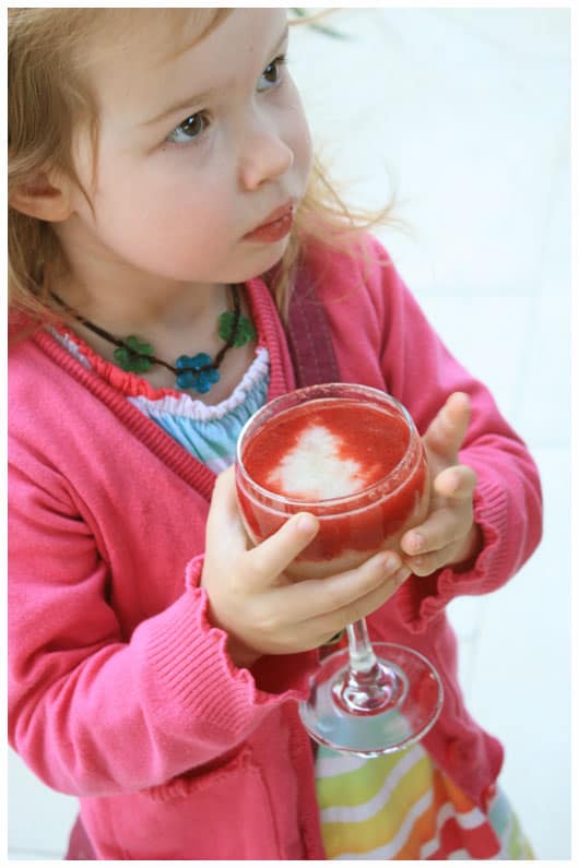 girl holding a glass of fresh guava and strawberry juice