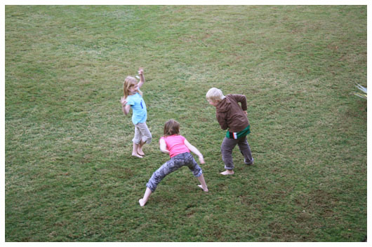 three children playing on the grass