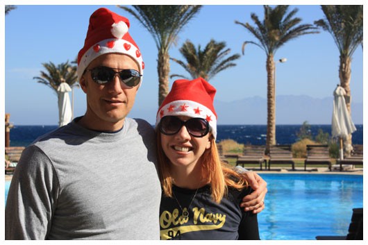 man and woman wearing santa hats