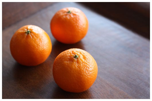 three clementines on a wood tray