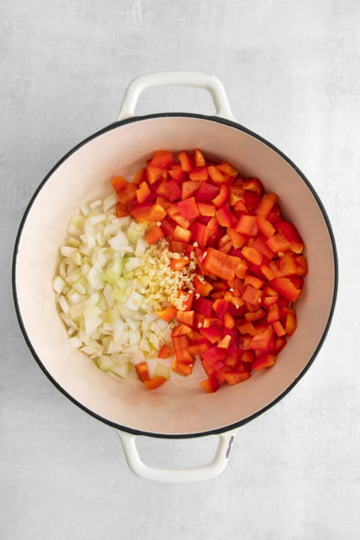 Diced bell peppers and diced onions in a soup pot