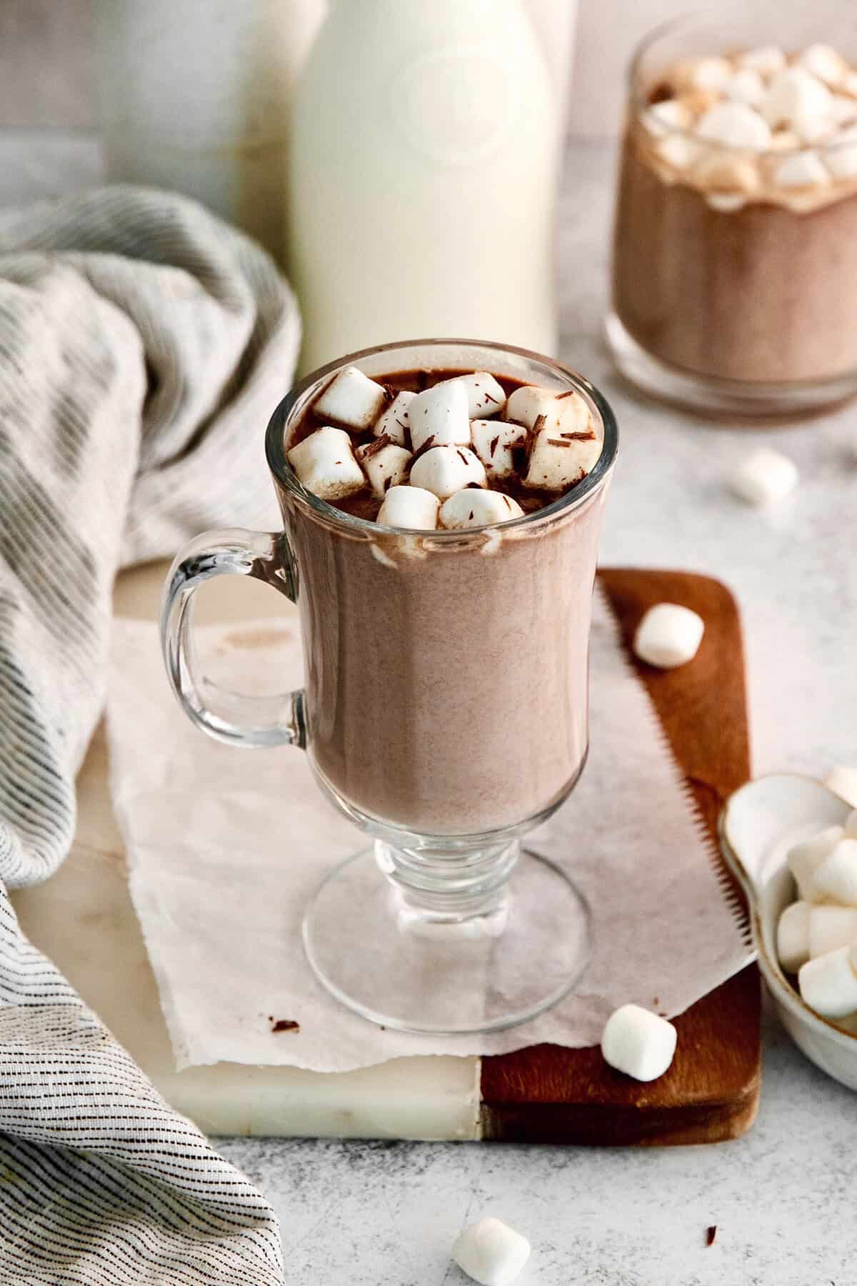 Hot chocolate in glass mug with marshmallows and shaved chocolate for garnish