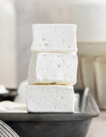 Stack of 3 homemade marshmallows on edge of sheet pan
