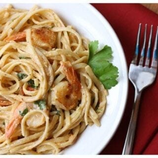 a plate of shrimp and tomato pasta