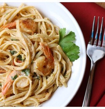 a plate of shrimp and tomato pasta