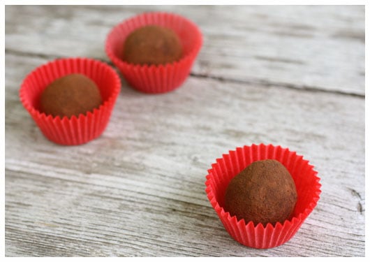 three truffles in red paper wrappers