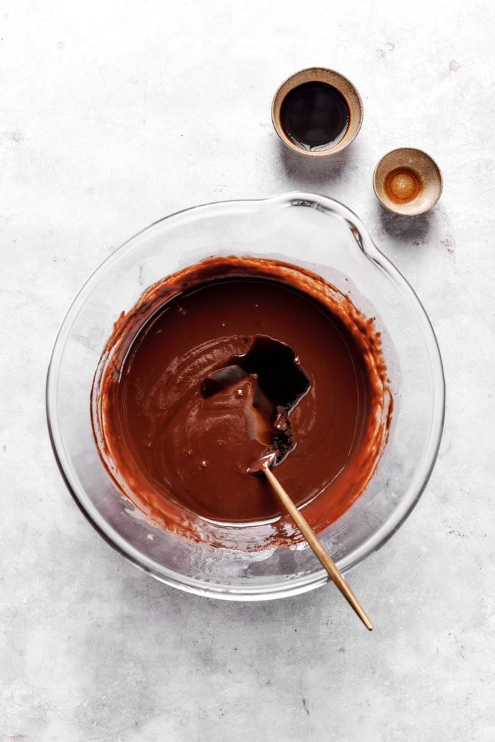 Spoon stirring vanilla and coffee into chocolate truffle mixture