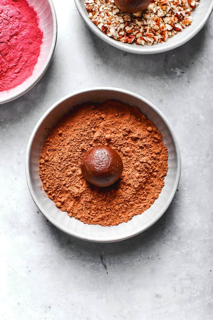 Rolling chocolate truffle in cocoa powder
