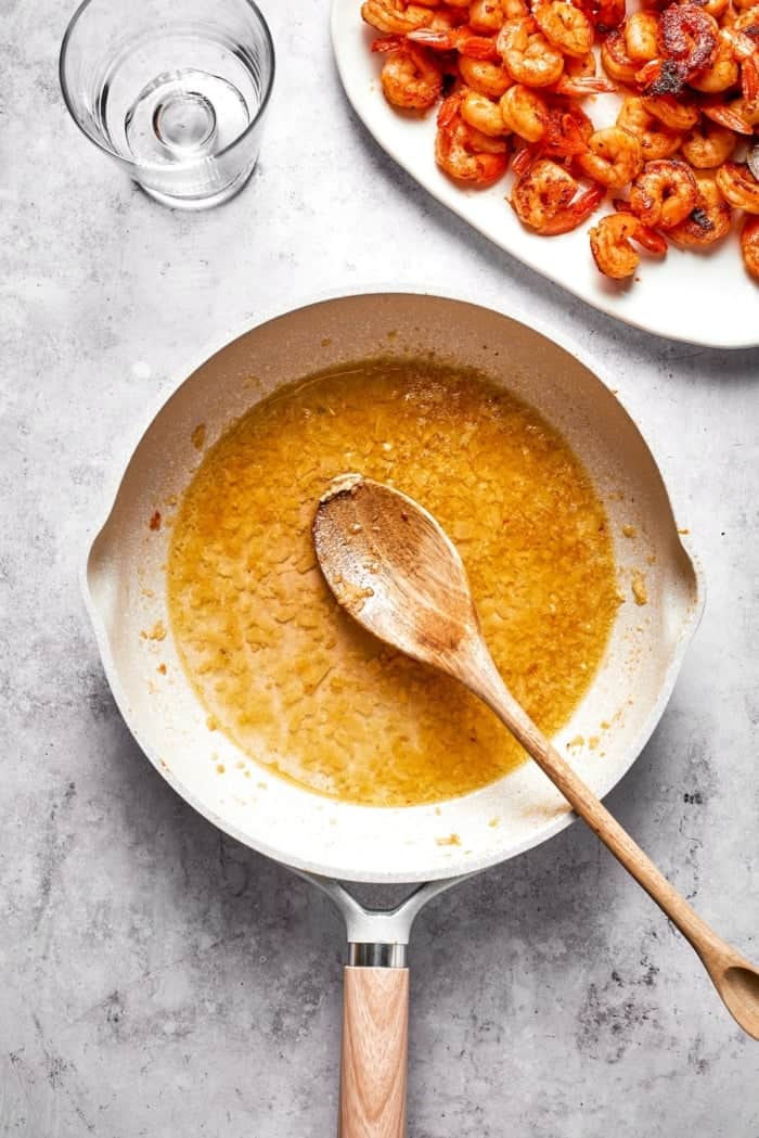 Wine added to sauteed garlic and onion in skillet.