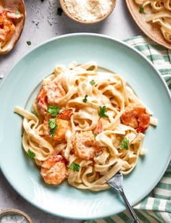 Fork on plate of creamy shrimp pasta.