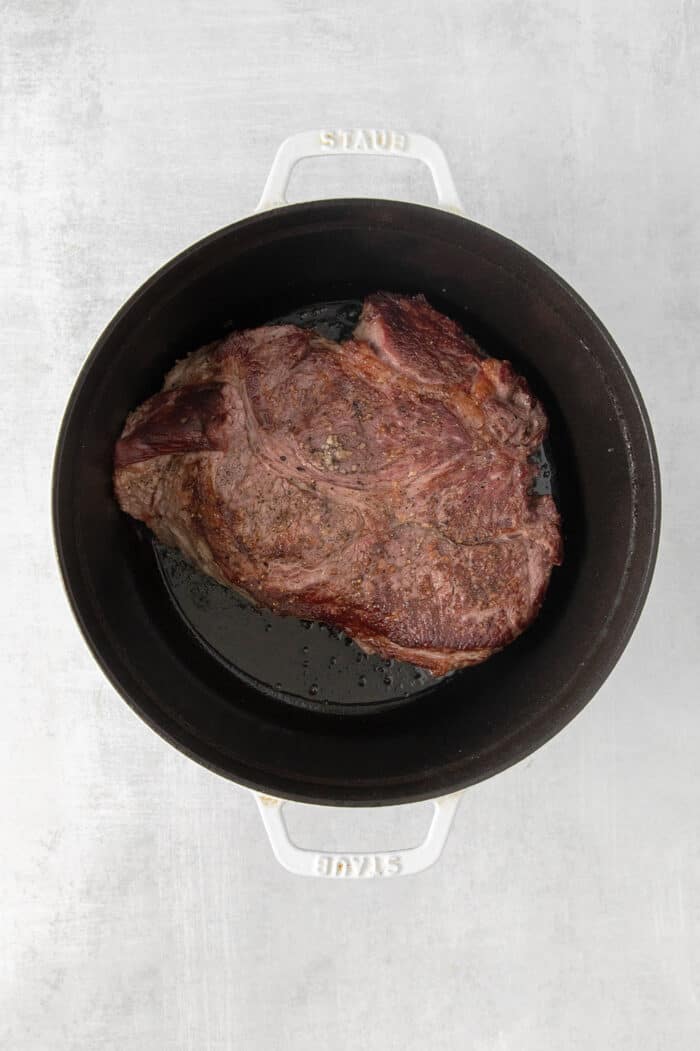 Overhead view of a chuck roast in a stock pot