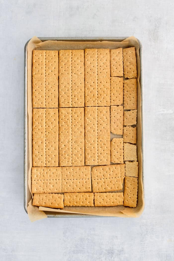 Adding the layer of graham crackers in the baking sheet.