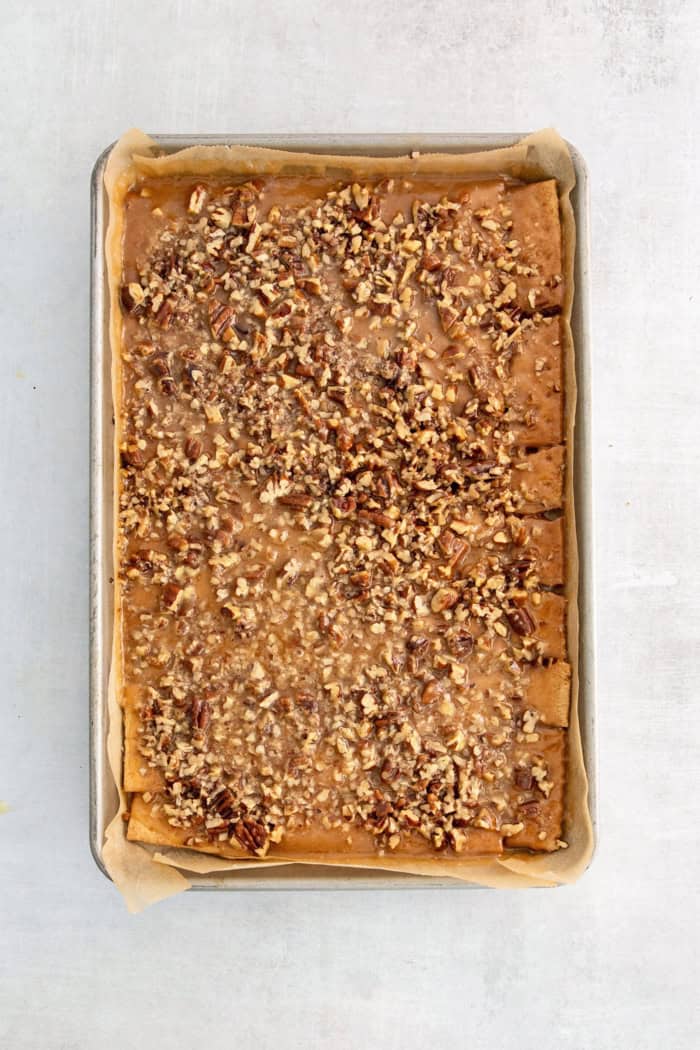Graham crackers with melted butter-sugar mixture and pecans on top.