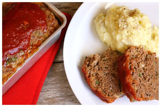 two slices of meatloaf with mashed potatoes on a plate