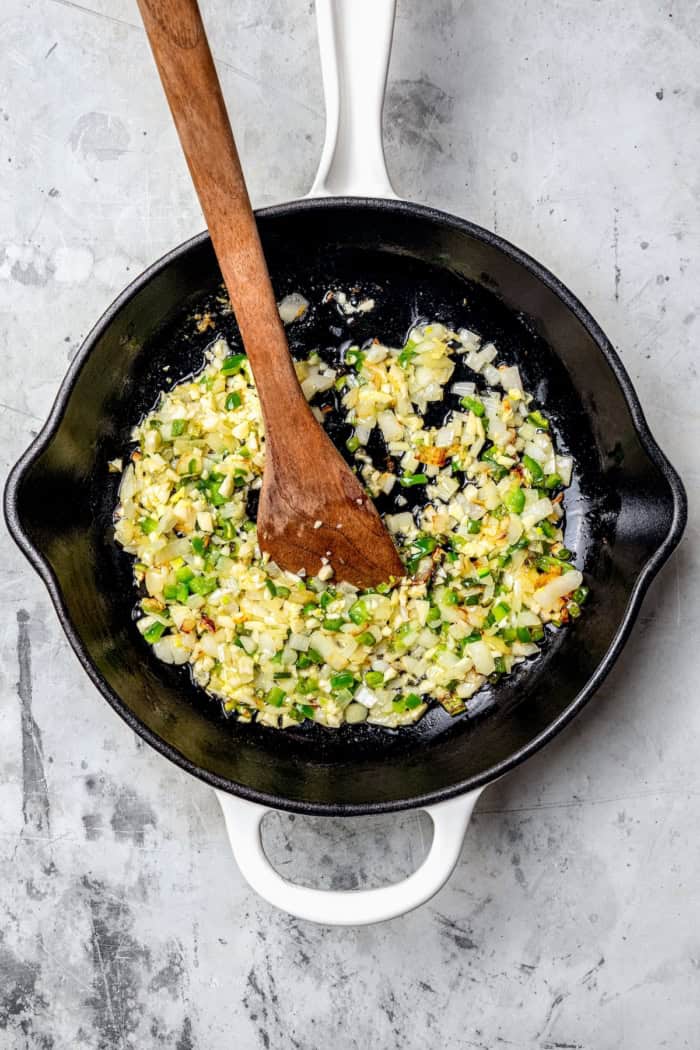 Jalapenos and onions cooking in skillet.