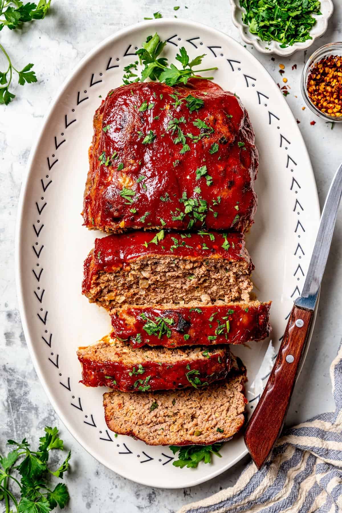 Spicy meatloaf on platter with 4 slices cut.