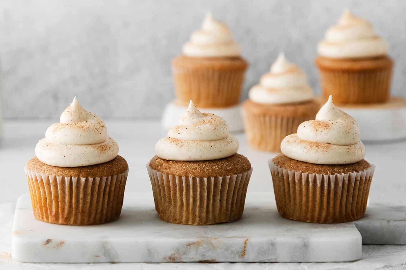 Snickerdoodle cupcakes with cream cheese frosting in a line