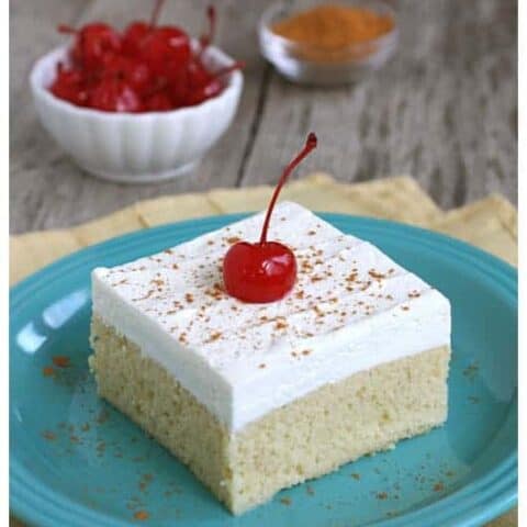 a slice of tres leches cake with a cherry on top