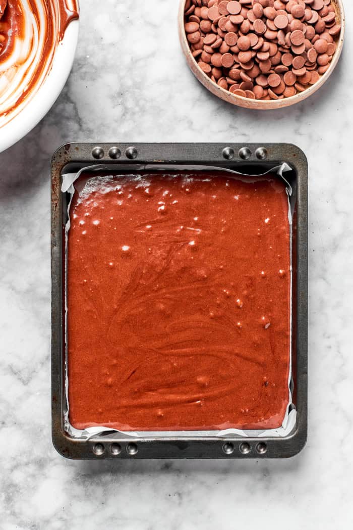Overhead view of brownie batter in parchment-lined pan