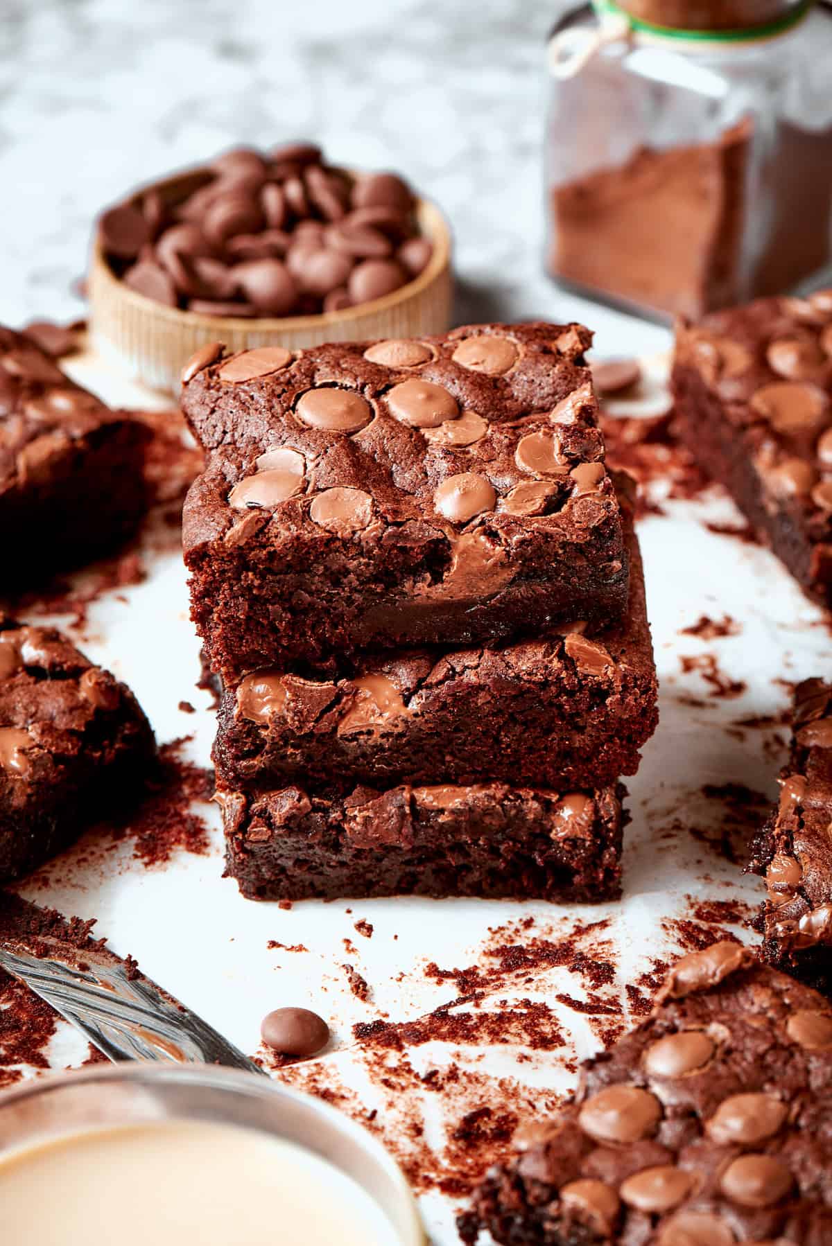 Stack of 3 fudgy brownies on parchment paper