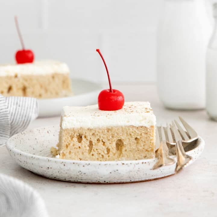 A slice of tres leches cake on a white plate