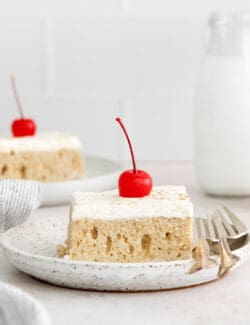 A slice of tres leches cake on a white plate