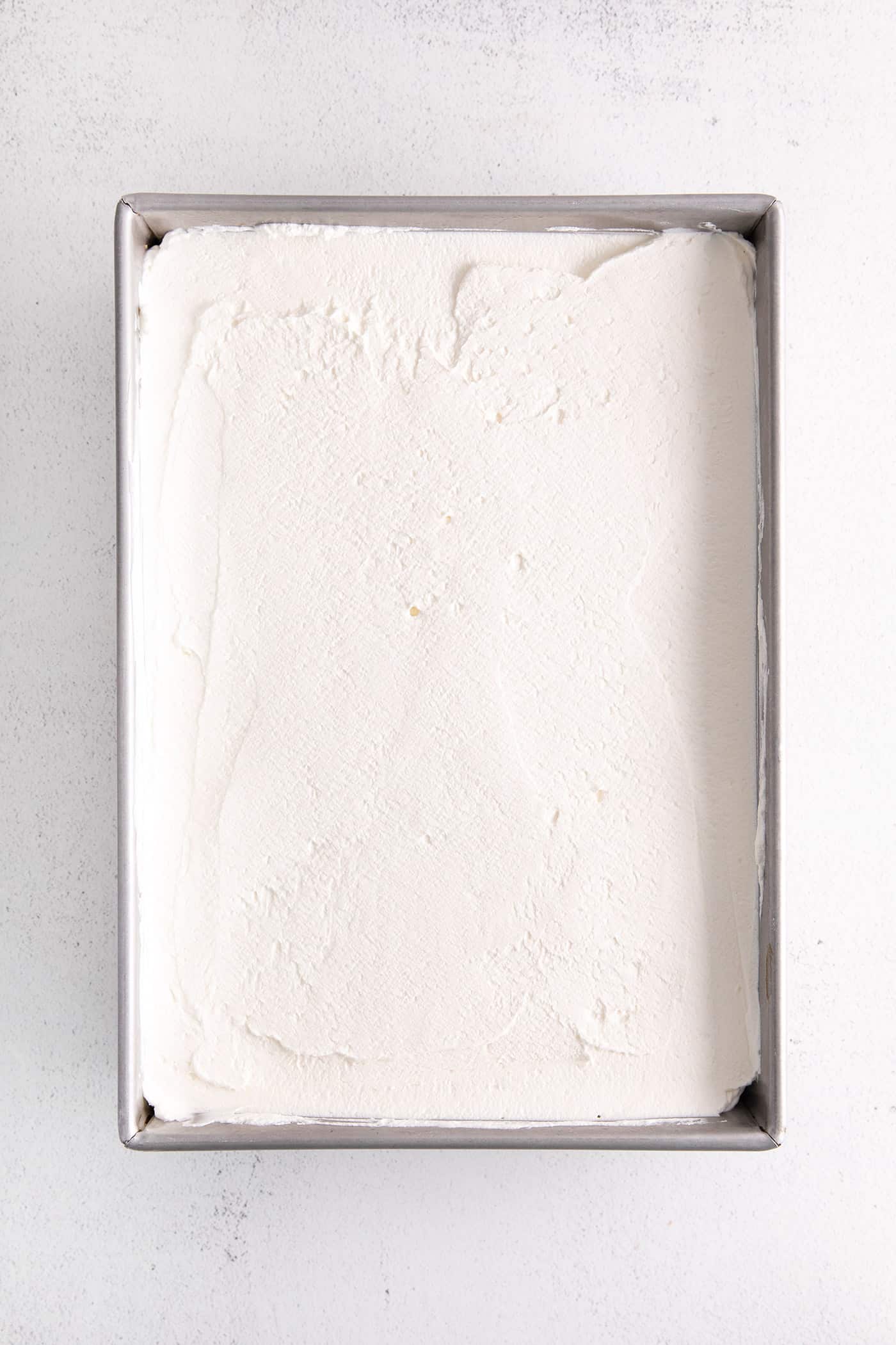 Whipped cream spread over cake