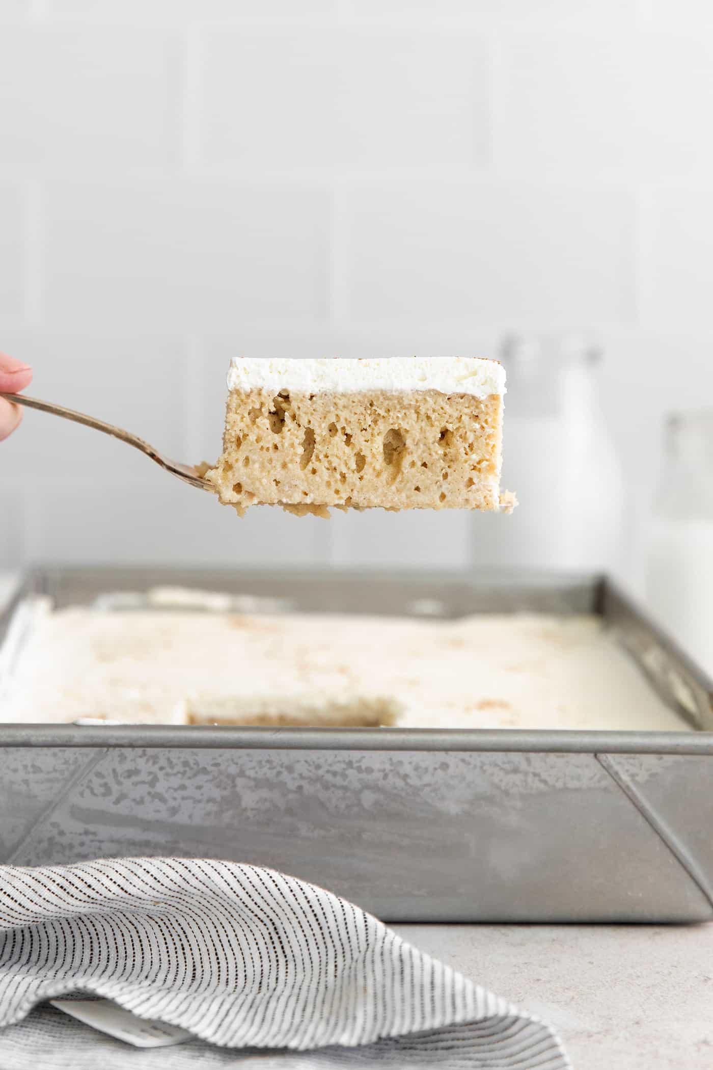 A spatula serving a slice of tres leche cake