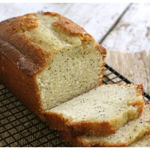 Poppyseed bread sliced up and sitting on a wire rack