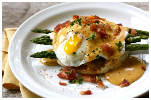 a white plate with eggs benedict and bbq hollandaise sauce