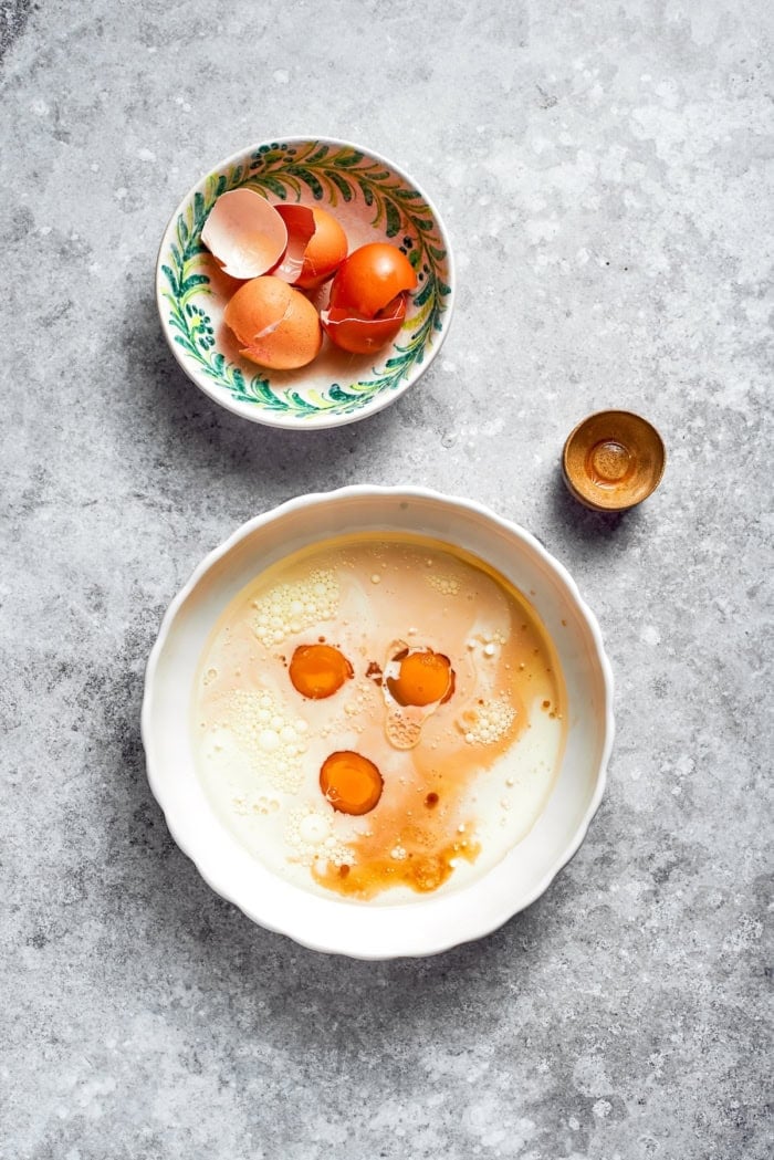 Eggs cracked into bowl of wet ingredients.