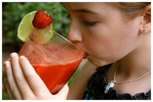 a girl drinking from a glass