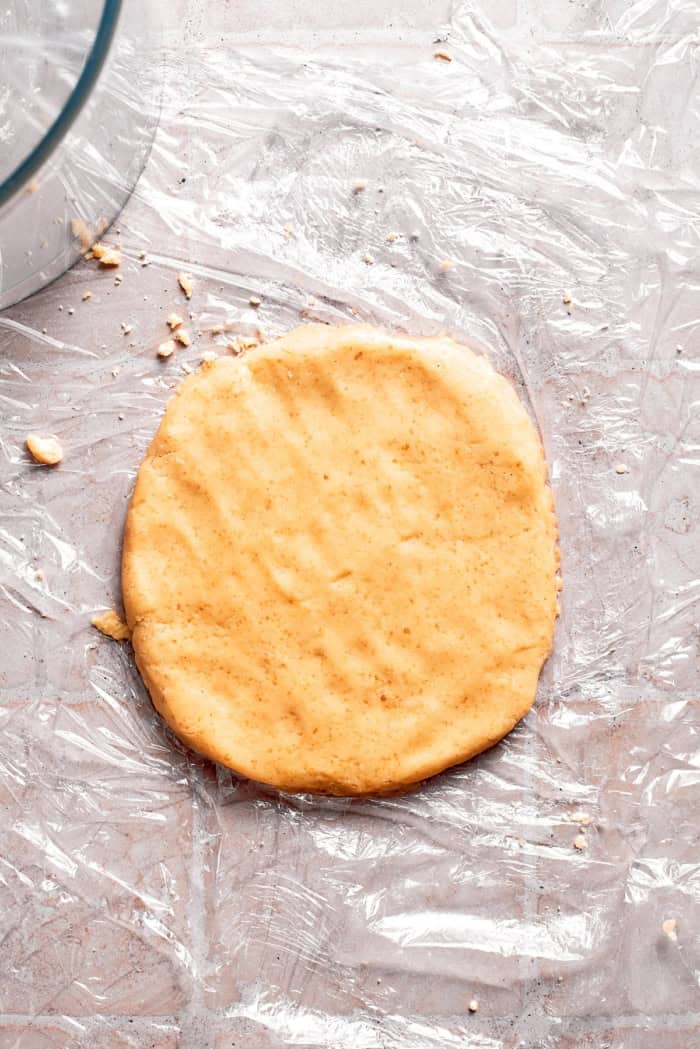 Cobbler topping rolled out onto plastic wrap.