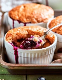 Spoonful of blueberry cobbler in ramekin.