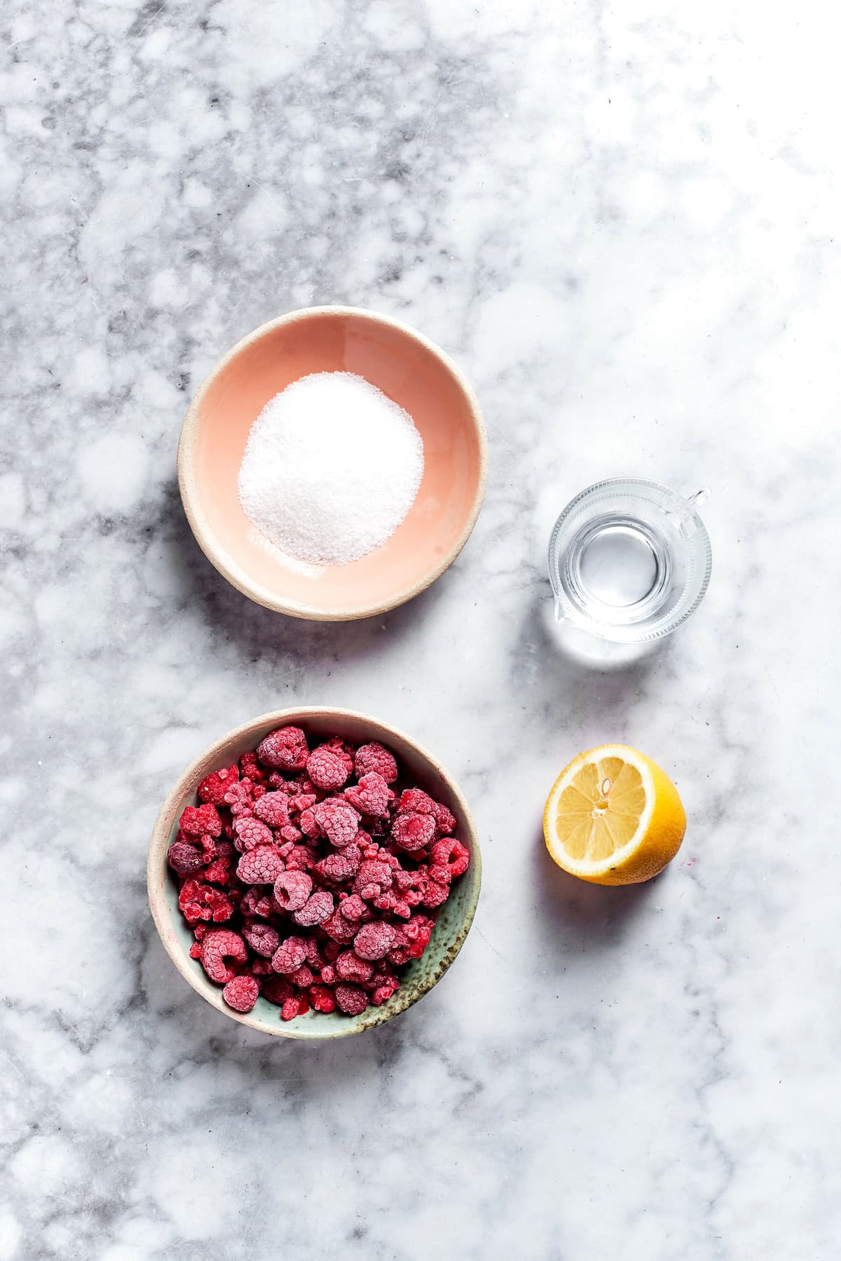 This rich raspberry cheesecake is sure to make your all-time-favorites list. It's rich, creamy, and elegant, but surprisingly easy to make! Overhead view of ingredients for raspberry sauce