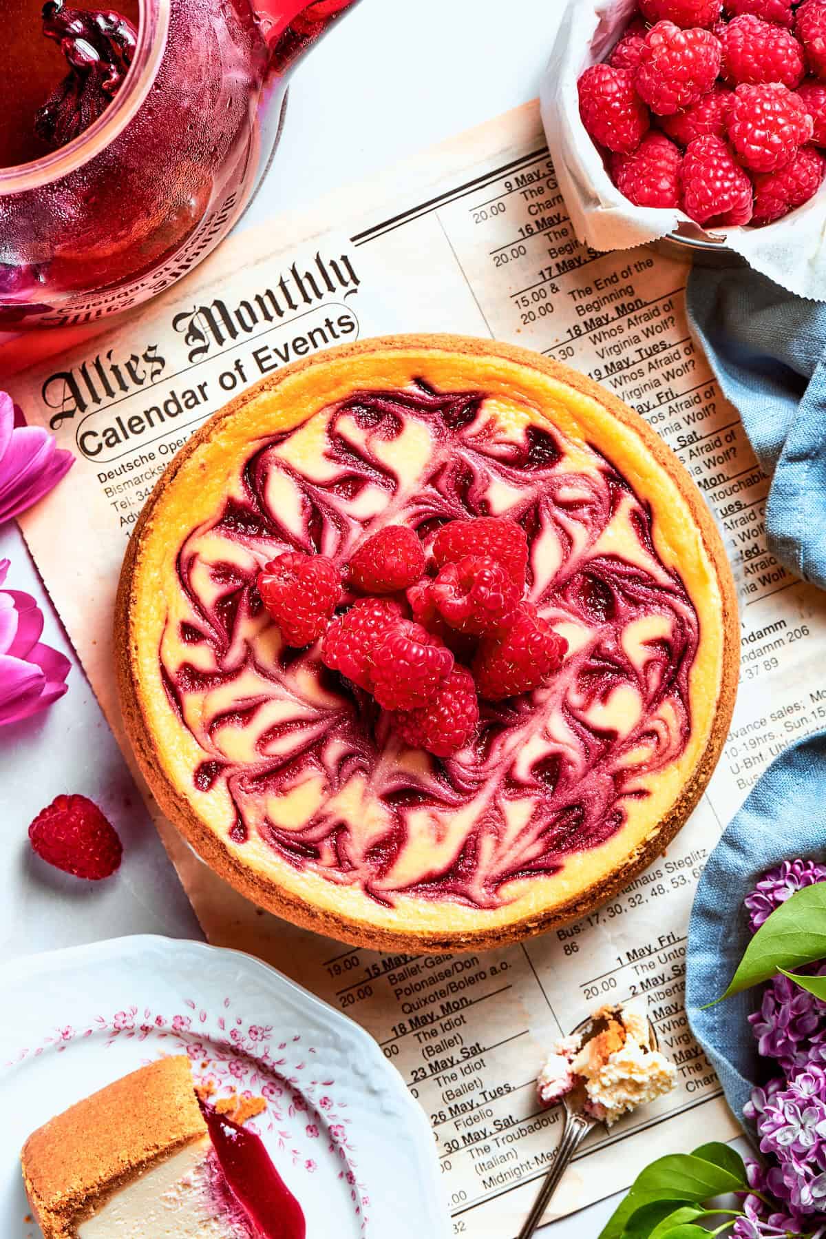 Overhead view of raspberry swirl cheesecake with raspberries piled on center