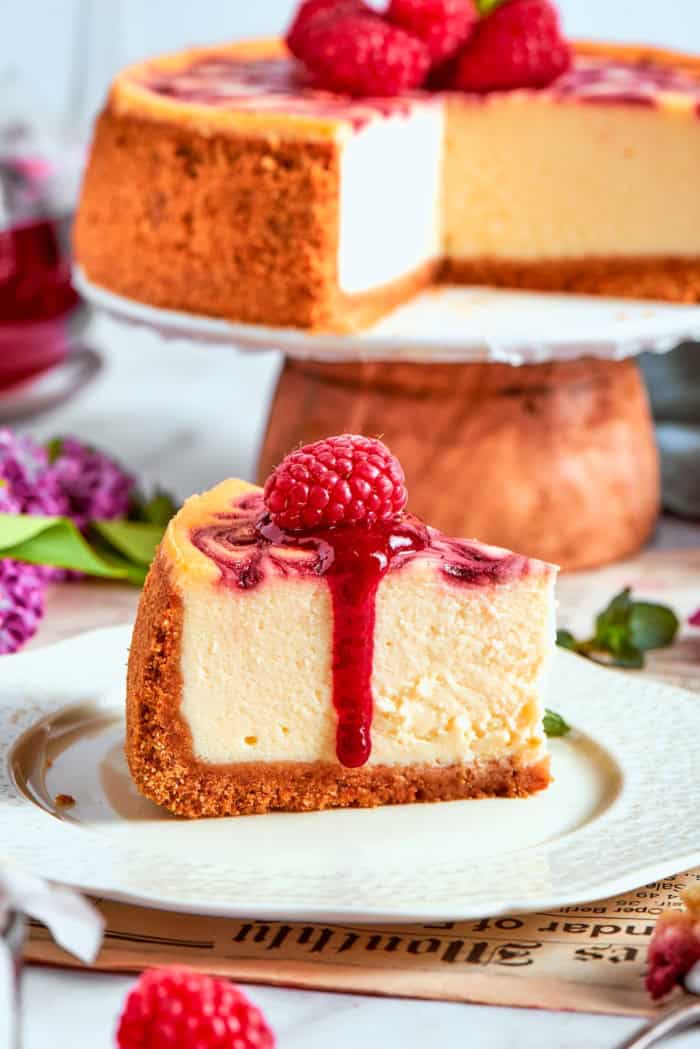 This rich raspberry cheesecake is sure to make your all-time-favorites list. It's rich, creamy, and elegant, but surprisingly easy to make! Slice of raspberry swirl cheesecake topped with raspberry sauce and fresh berry